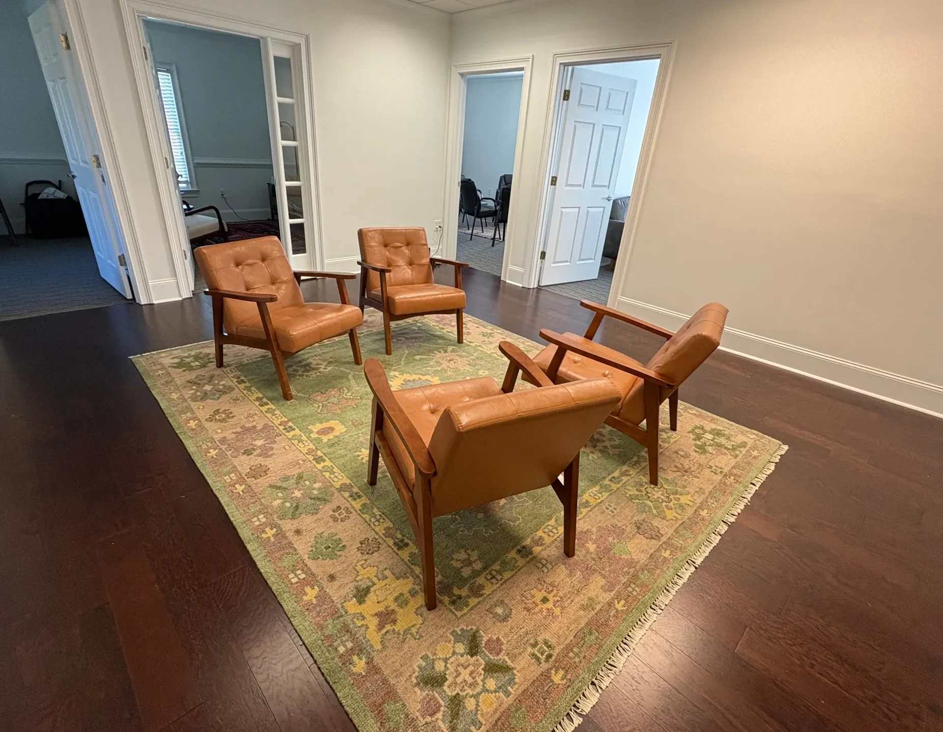 Waiting area at The Community in downtown Alpharetta, with four leather chairs on a rug